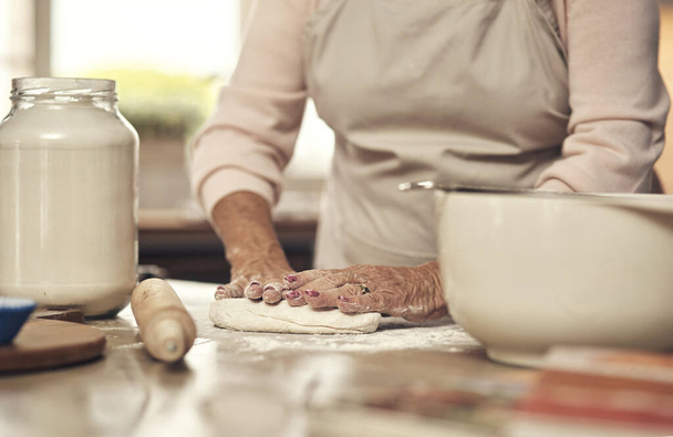 Baking is my favourite hobby. an unrecognizable person baking in the kitchen at home - Foto, Imagen