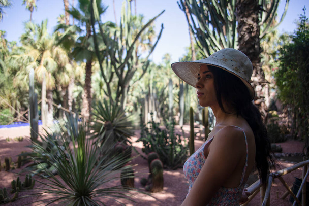 Kaunis turisti hattu vierailevat Berber Majorelle puutarha, joka on kasvitieteellinen puutarha Marrakech (Marokko), joka on suunnitellut ranskalainen ulkomaalainen taiteilija Jacques Majorelle. - Valokuva, kuva