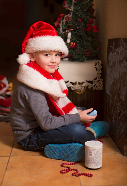 jongen in het interieur van het huis ingericht voor het nieuwe jaar en kerst - Foto, afbeelding
