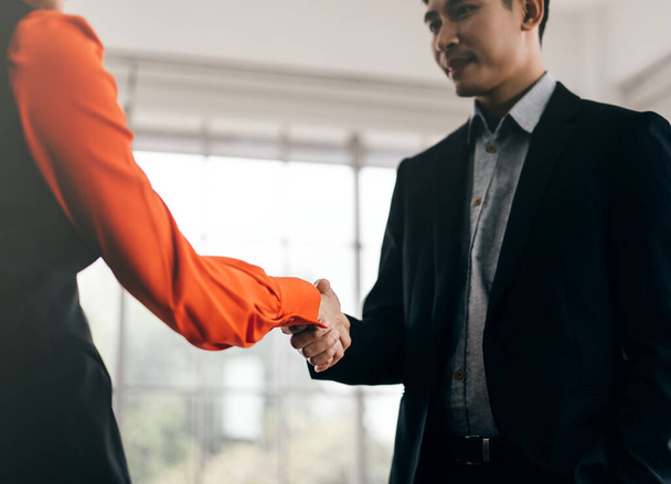 Asiatische erwachsene Geschäftsleute und Partnerinnen geben sich nach erfolgreichem Teamwork die Hand. Gruß-Körpersprache. Hintergrund im Marketingbüro. - Foto, Bild
