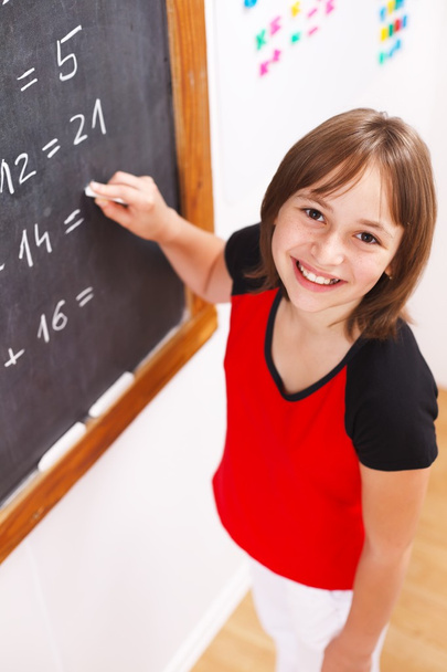 Schoolgirl looking up in front of chalkboard - Foto, Imagem