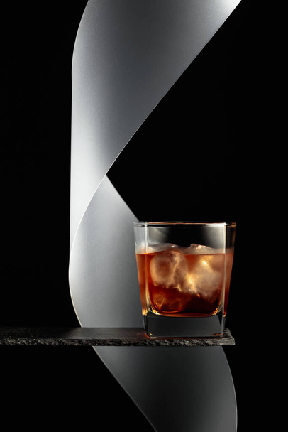 Whisky mit Eis auf schwarzem Hintergrund. - Foto, Bild
