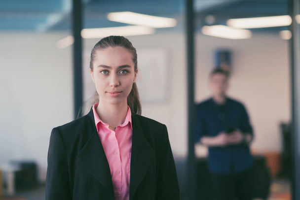 Portrait of young smiling business woman in creative open space coworking startup office. Successful businesswoman standing in office with copyspace. Coworkers working in background. High quality - Φωτογραφία, εικόνα