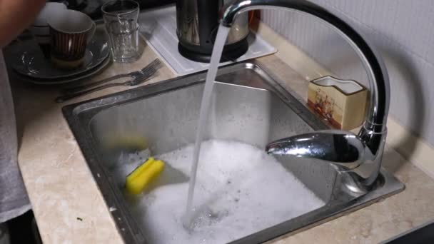 πλύσιμο πιάτων. τα αρσενικά χέρια σε αφρό πλένουν το πιάτο με απορρυπαντικό και σφουγγάρι στην κουζίνα στο σπίτι. - Πλάνα, βίντεο