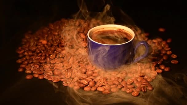 Una tazza di caffè tra chicchi di caffè tostati in fumo leggero, video hd e slow motion. - Filmati, video