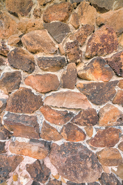 Жорсткий круглий каркас в Тусоні, штат Арізона. Зблизька кам "яна стіна з нерівномірними природними великими скелями і цементними пломбами.. - Фото, зображення