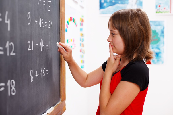 Girl standing in front of chalkboard and thinking - Foto, Imagem