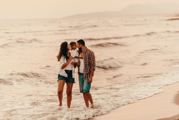 The family enjoys their vacation as they walk the sandy beach with their son. Selective focus . High quality photo - Fotografie, Obrázek