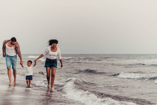 The family enjoys their vacation as they walk the sandy beach with their son. Selective focus . High quality photo - Zdjęcie, obraz