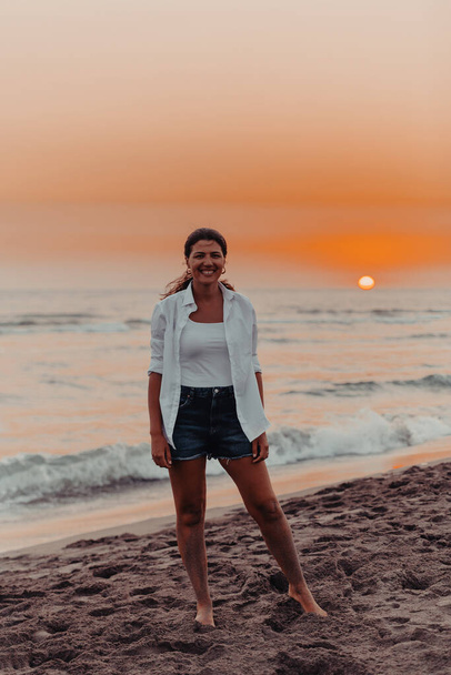 Happy Carefree Woman Enjoying Beautiful Sunset on the Beach. Selective focus . High quality photo - Фото, изображение
