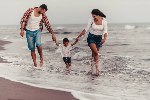 The family enjoys their vacation as they walk the sandy beach with their son. Selective focus . High quality photo - 写真・画像
