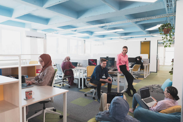 Portrait of young smiling business woman in creative open space coworking startup office. Successful businesswoman standing in office with copyspace. Coworkers working in background. High quality - Foto, imagen