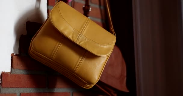 Dámské kožené kabelky visí na háku v chodbě detailní 4k film zpomalení. Příslušenství pro ženy koncept - Záběry, video