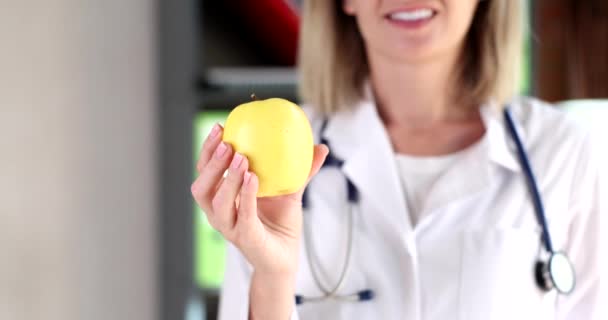 Voedingsdeskundige met groene appel in zijn handen close-up 4k film slow motion. Juiste voeding gewichtsverlies concept - Video