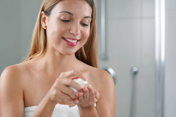 Δερμοκαλλυντική φροντίδα γυναίκα εφαρμογή κρέμα με ρετινόλη αντι-σημάδια στο μπάνιο - Φωτογραφία, εικόνα