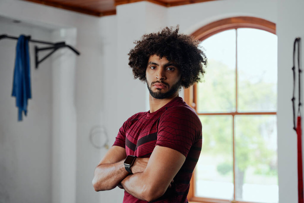 Portrait of focused young middle eastern man in sportswear with arms crossed at the gym - Фото, зображення