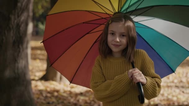 Portret van een blank meisje in het park met een kleurrijke paraplu. Opgenomen met RED helium camera in 8K.   - Video