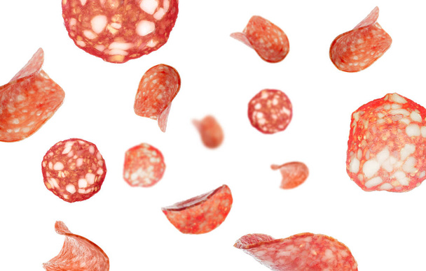 Muitas fatias voadoras de delicioso salame isolado em branco - Foto, Imagem