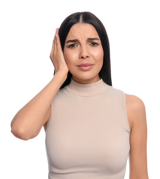 Young woman suffering from ear pain on white background - Photo, image