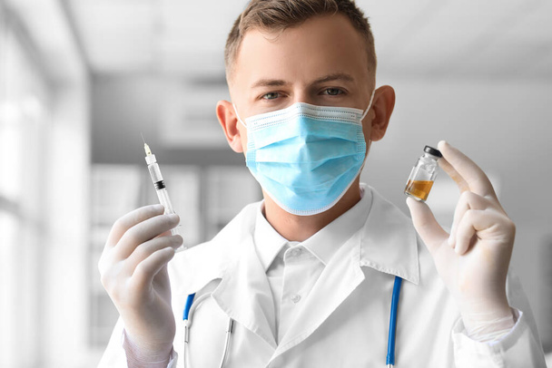 Врач в медицинской маске со шприцем и ампулой в больнице, крупный план - Фото, изображение