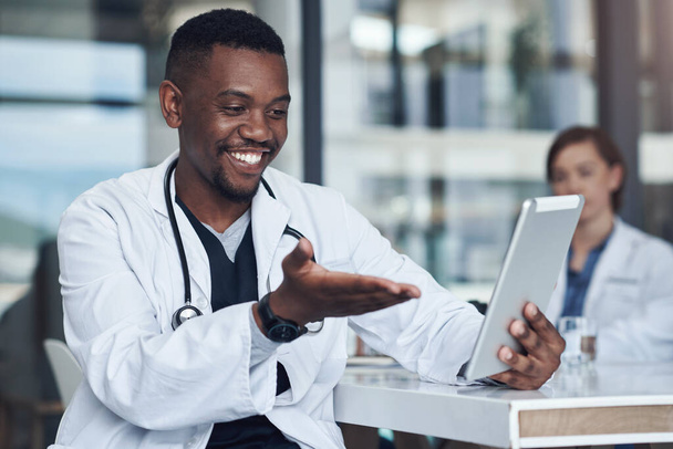 Hallo, wie geht es dir? ein junger Arzt macht eine Pause und benutzt sein digitales Tablet - Foto, Bild