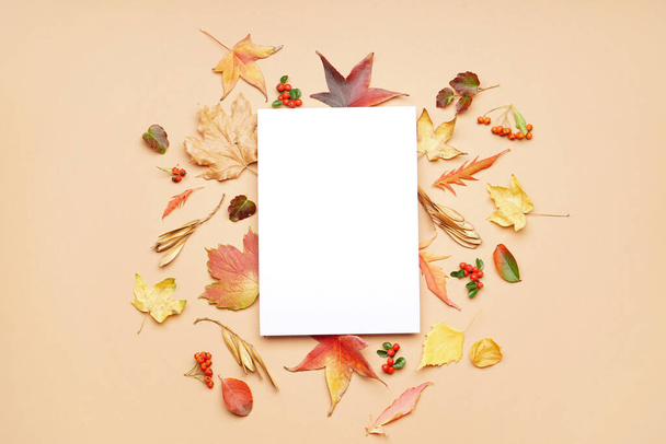Composition avec carte blanche et feuilles d'automne sur fond de couleur - Photo, image