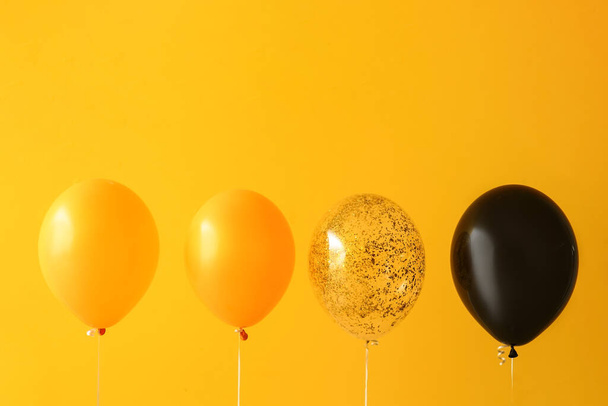 Αποκριάτικα μπαλόνια κοντά κίτρινο τοίχο - Φωτογραφία, εικόνα