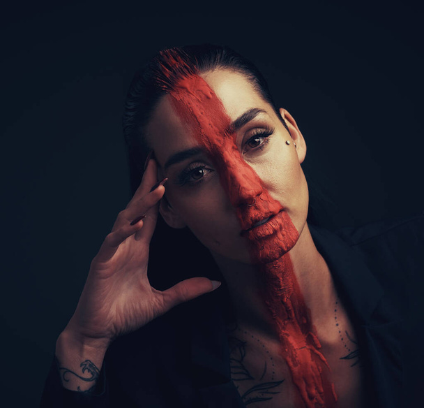 Dont live life according everyone elses expectations. Studio shot of a young woman posing with paint on her face on a black background - Foto, Bild
