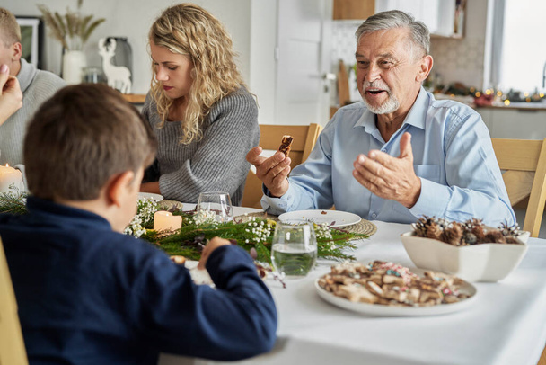 クリスマスの間に食べると陽気に話す白人の家族｜Ev - 写真・画像