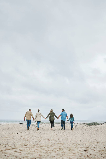 Holiday, family and walking beach in summer vacation, travel and freedom in South Africa. Love, freedom and care grandparents, parents and kid relax, bond and enjoy winter ocean trip together. - Фото, зображення