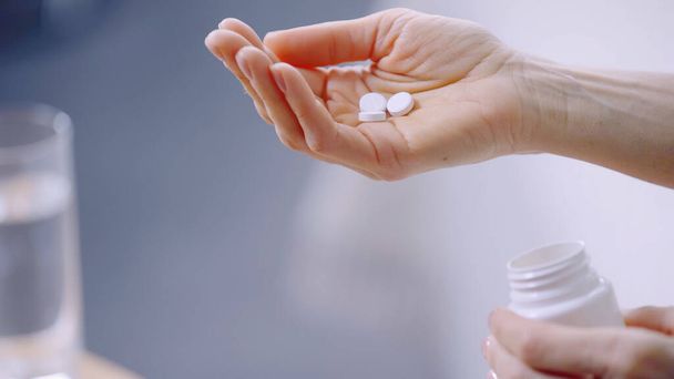 visão cortada da mulher segurando pílulas na mão  - Foto, Imagem