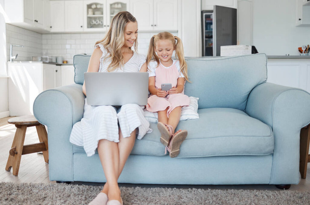 Technológia, gyermek és anya tanulás egy mobil app, dolgozik egy laptop és boldog az interneten a kanapén a házban. Lány és anya streaming képregény egy telefon számítógép a munka. - Fotó, kép
