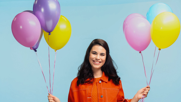 happy young woman with colorful party balloons isolated on blue - Fotografie, Obrázek