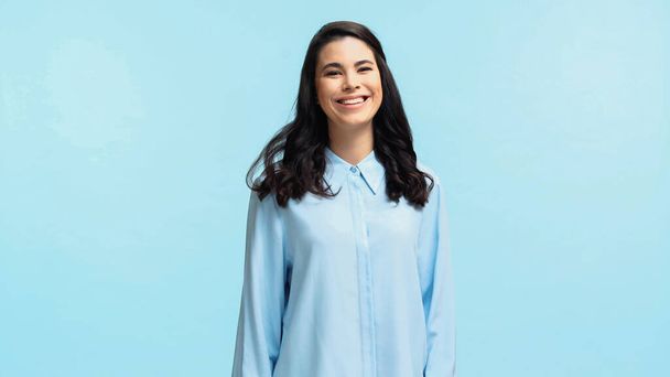 positive young woman in shirt looking at camera isolated on blue - Fotoğraf, Görsel