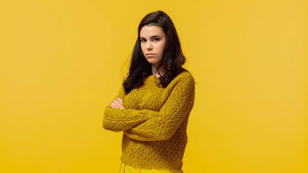sad young woman in autumnal sweater standing with crossed arms isolated on yellow - Fotoğraf, Görsel