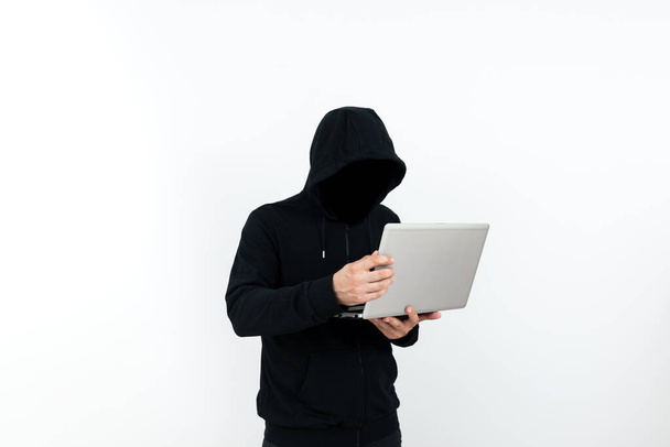 Człowiek stojący z laptopem prezentujący cyberbezpieczeństwo. - Zdjęcie, obraz