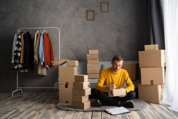 Startup small business entrepreneur SME, man packing box. Portrait of young small business owner in home office, online sell marketing delivery, SME e-commerce telemarketing concept - Photo, Image