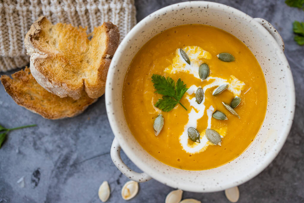 Vegetarian autumn pumpkin cream soup with seeds - Foto, afbeelding