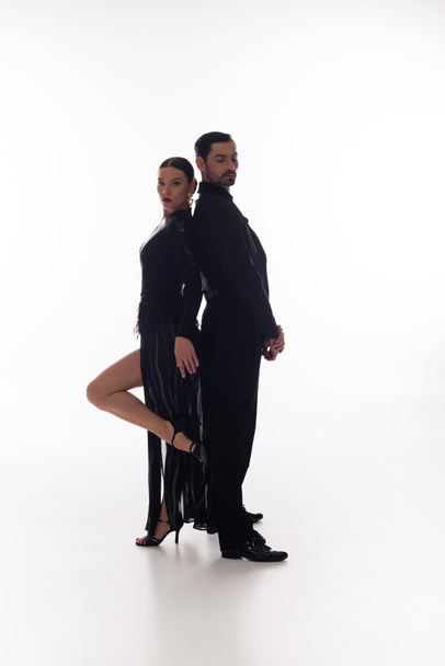 Pair of professional dancers standing back to back on white background  - Photo, Image