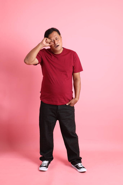 The 40s adult overweight Asian man standing on the pink background. - 写真・画像