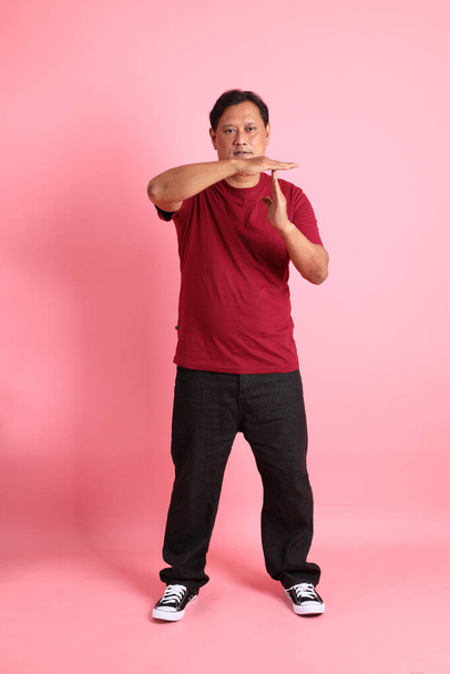 40s dospělý nadváha asijské muž stojící na růžovém pozadí. - Fotografie, Obrázek