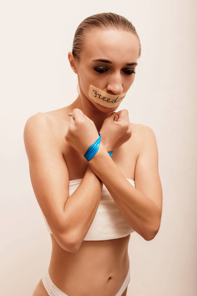 Девушка со связанными руками и заклеенным ртом без одежды. Высокое качество фото - Фото, изображение