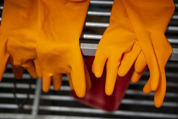 Kullanımdan sonra üst üste konmuş lastik turuncu eldivenler. - Fotoğraf, Görsel