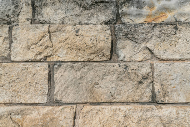 Закріпіть вид на кам'яну цегляну стіну в місті Остін Техас. Текстура і візерункова поверхня будинку з грубою текстурою і прямокутними різьбленими каменями.. - Фото, зображення