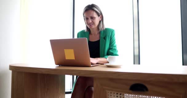 Uśmiechnięta bizneswoman pracująca na laptopie w miejscu pracy 4k film slow motion. Koncepcja pracy na własny rachunek online - Materiał filmowy, wideo