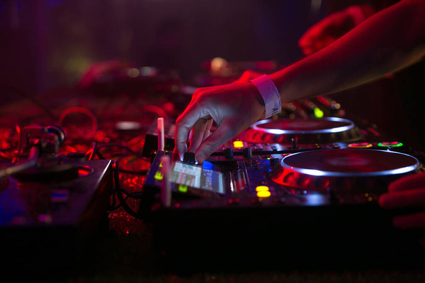 Közelről láthatod, ahogy egy DJ játszik a mixerrel, miközben előadást tart. Kiváló minőségű fénykép - Fotó, kép