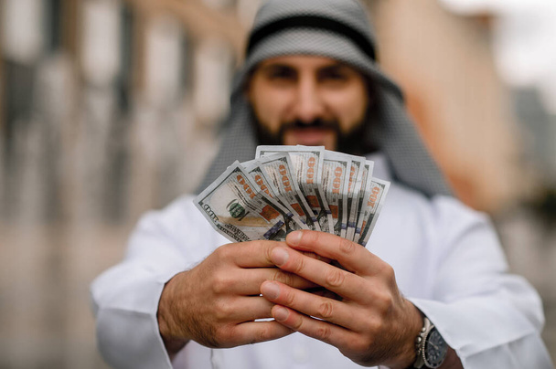 Hombre rico. Oriente Medio joven sosteniendo dólares en las manos - Foto, imagen