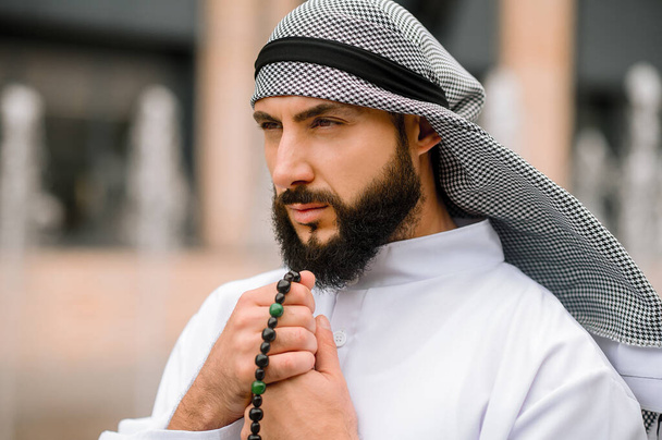 Rezando. barbudo árabe chico en tradicional headwear lectura oraciones - Foto, Imagen