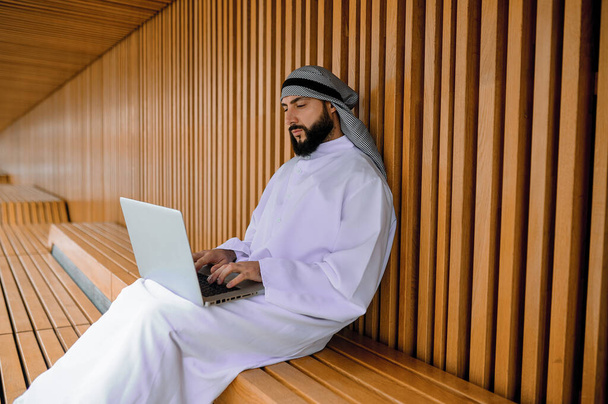Teen töitä. Nuori arabialainen liikemies työskentelee kannettavan tietokoneen ja etsivät mukana - Valokuva, kuva