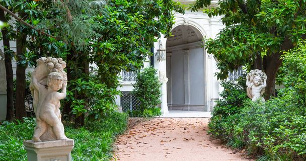 ミラノ,イタリア- Circa 2021年6月:庭付きイタリアのヴィラの入り口。豪華な緑の外観 - 写真・画像